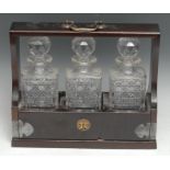 A late Victorian/early Edwardian EPNS-mounted mahogany tantalus, typically enclosing three cut glass