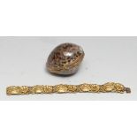 An early 20th century cowrie shell purse, 7cm wifde; a gilt metal bracelet (2)