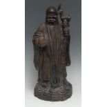 A Chinese hardwood figure, carved as Shou Lao, he stands, holding a ripe peach and prunus ruyi, 41cm