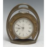 An early 20th century brass novelty equestrian desk timepiece, as a horseshoe within a stirrup,