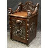 A Victorian Jacobean revival purdonium in the form of a seat, carved back, and arms, lion mask