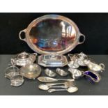 A pair of sliver plated twin handled entree dishes and covers; another, navette; a bottle stand;