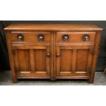 A 20th century oak sideboard, rectangular top above a pair of short drawers and a pair of cupboard