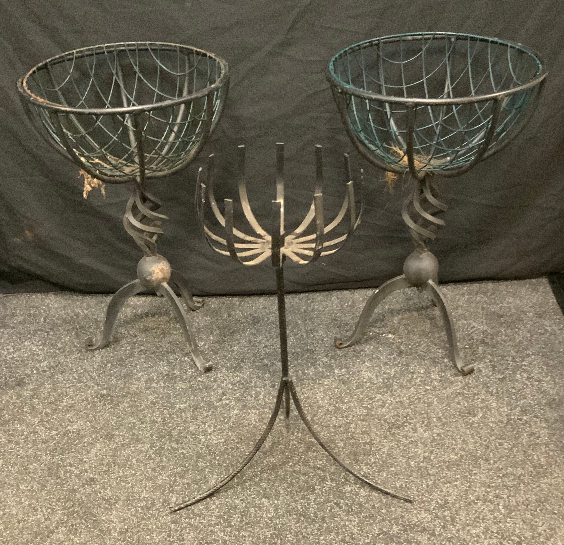 A pair of circular wirework basket planters, spiral vortex column, tripod feet, 64.5cm high, 43cm