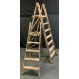 A set of seven tread wooden step ladders, 197cm high; another 151cm high (2)