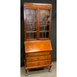 A mid 20th century mahogany bureau bookcase, a pair of astragal glazed doors enclosing three