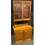 A Roger Bellinger African mahogany and elm cabinet, a pair of shaped cupboard doors enclosing