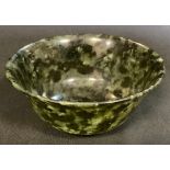 A polished green stone circular bowl, possibly Nephrite Jade, 10cm diameter.