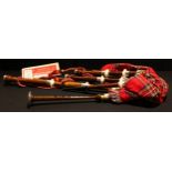 A set of Scottish tartan bagpipes, a music book, soft carry case