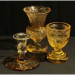 A Bohemian amber flashed glass ogee shaped pedestal vase, engraved with a band of fruiting vine,