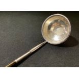 A George III silver toddy ladle, the bowl set with a George II shilling of 1747, twisted whale