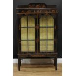 An early 20th century japanned and chinoiserie display cabinet, shaped half gallery above a pair