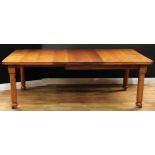 An early 20th century oak extending dining table, rounded rectangular top with two additional
