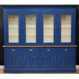 A substantial painted and pine bookcase or dresser, moulded cornice above four glazed doors, each