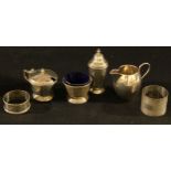 A George V silver Regency style three piece cruet set, blue glass liners, Birmingham 1931, silver