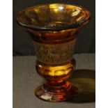 An early 20th century Moser Amber glass thistle shaped vase, gilt band of warriors, 15.5cm high,