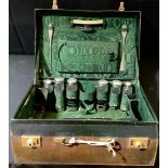 A George V leather travelling dressing case, enclosing an arrangement of silver mounted bottles,