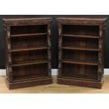 A pair of late Victorian oak pier library bookcases, each with a rectangular top with floral lunette