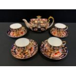 A Royal Crown Derby 2451 teapot, four conforming cups and saucers.