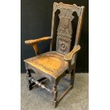 A 17th century Jacobean style oak arm chair, carved throughout, 95cm high.