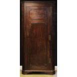 A 19th century mahogany floor-standing splay-fronted corner cupboard, dentil cornice, full length