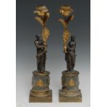 A pair of 19th century gilt and dark-patinated bronze figural mantel sticks, each cast as a