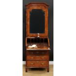 A George I walnut bureau book cabinet, domed cornice above a bevelled mirror door enclosing two