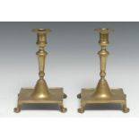 A pair of Spanish brass table candlesticks, knopped pillars, domed socles, square bases, bracket