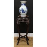 A Chinese hardwood vase or jardiniere stand, circular top with inset soapstone panel, above a deep