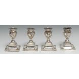 A set of four Victorian Adam Revival silver candlesticks, urnular sconcesin relief with Classical