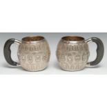 A pair of Malaysian silver ovoid presentation mugs, the rims inscribed in wrigglework: From