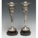 A pair of Chinese silver trumpet shaped vases, pierced and chased with blossoming prunus, wavy