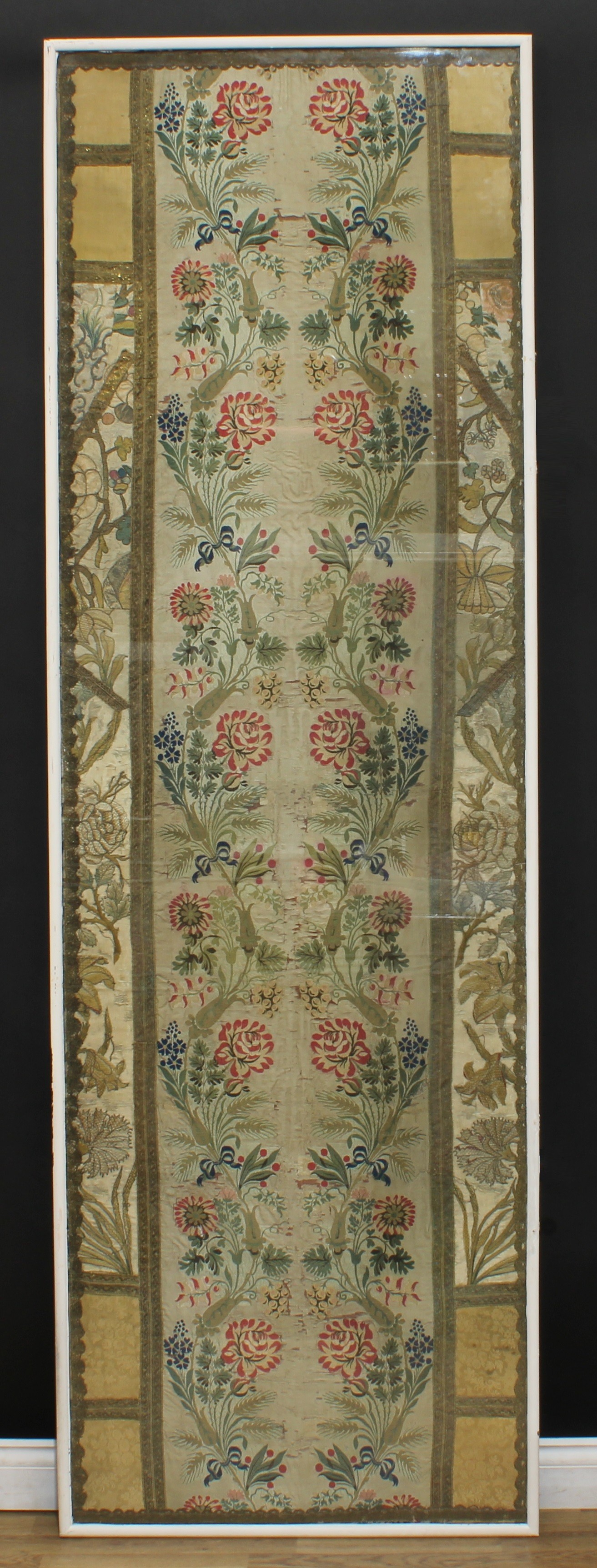 An 18th century silk panel, the central runner worked in coloured threads with opposing meandering