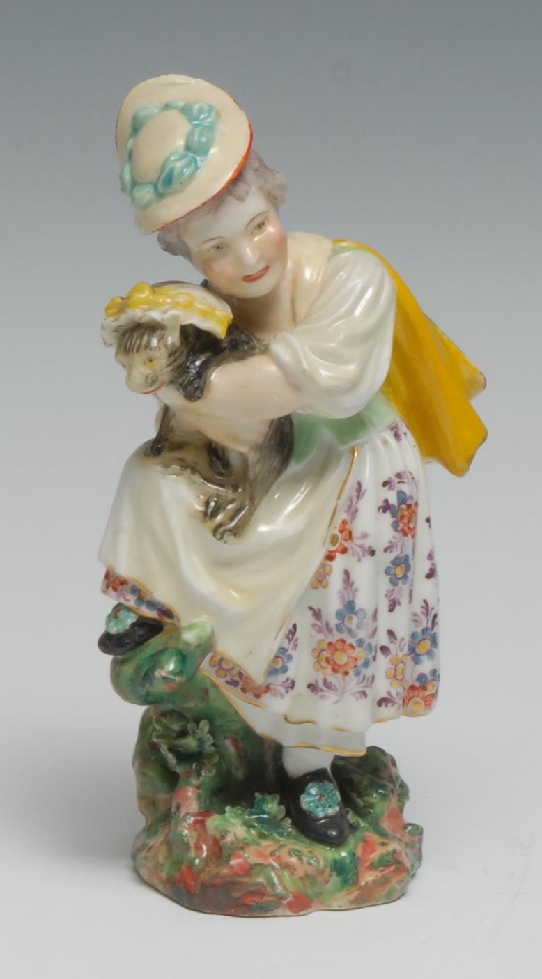 A Derby Patch Mark figure, Girl with Macaroni Cat, she wearing a a bonnet and floral dress, her arms