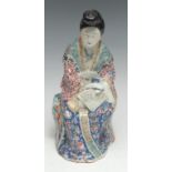 A Chinese porcelain figure, of a well-dressed lady, her face made-up and her hair dressed, seated on