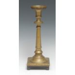 An 18th century brass candlestick, probably Spanish, broad drip pan, cast facetted pillar screw-