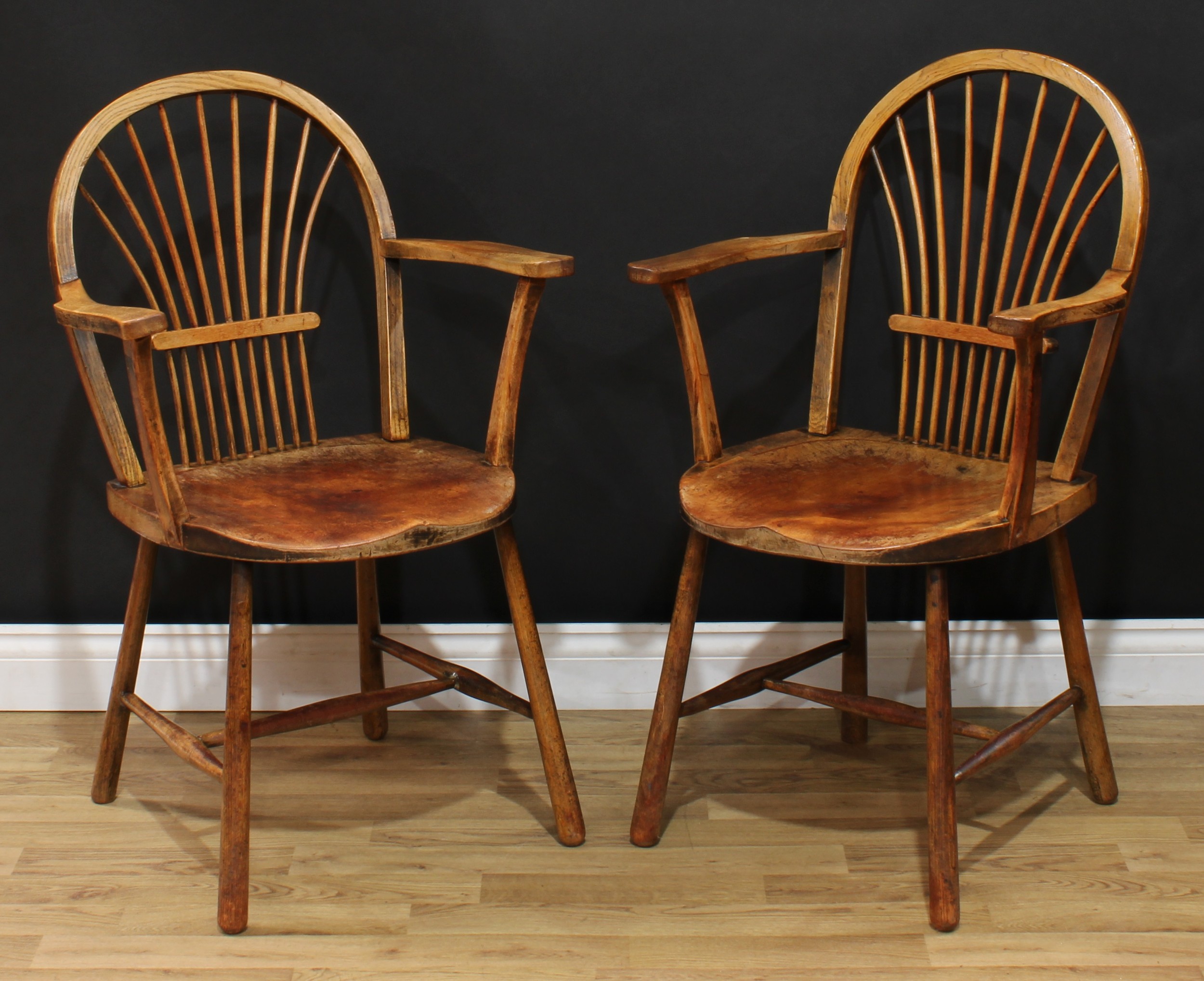 A pair of 19th century sheaf-back elbow chairs, of Windsor chair construction, hoop backs, saddle