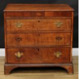 A George III oak chest, slightly oversailing top above a deep mahogany crossbanded frieze centred by