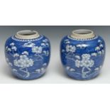 A near pair of Chinese ovoid ginger jars, painted with blossoming prunus on a ground of cracked ice,