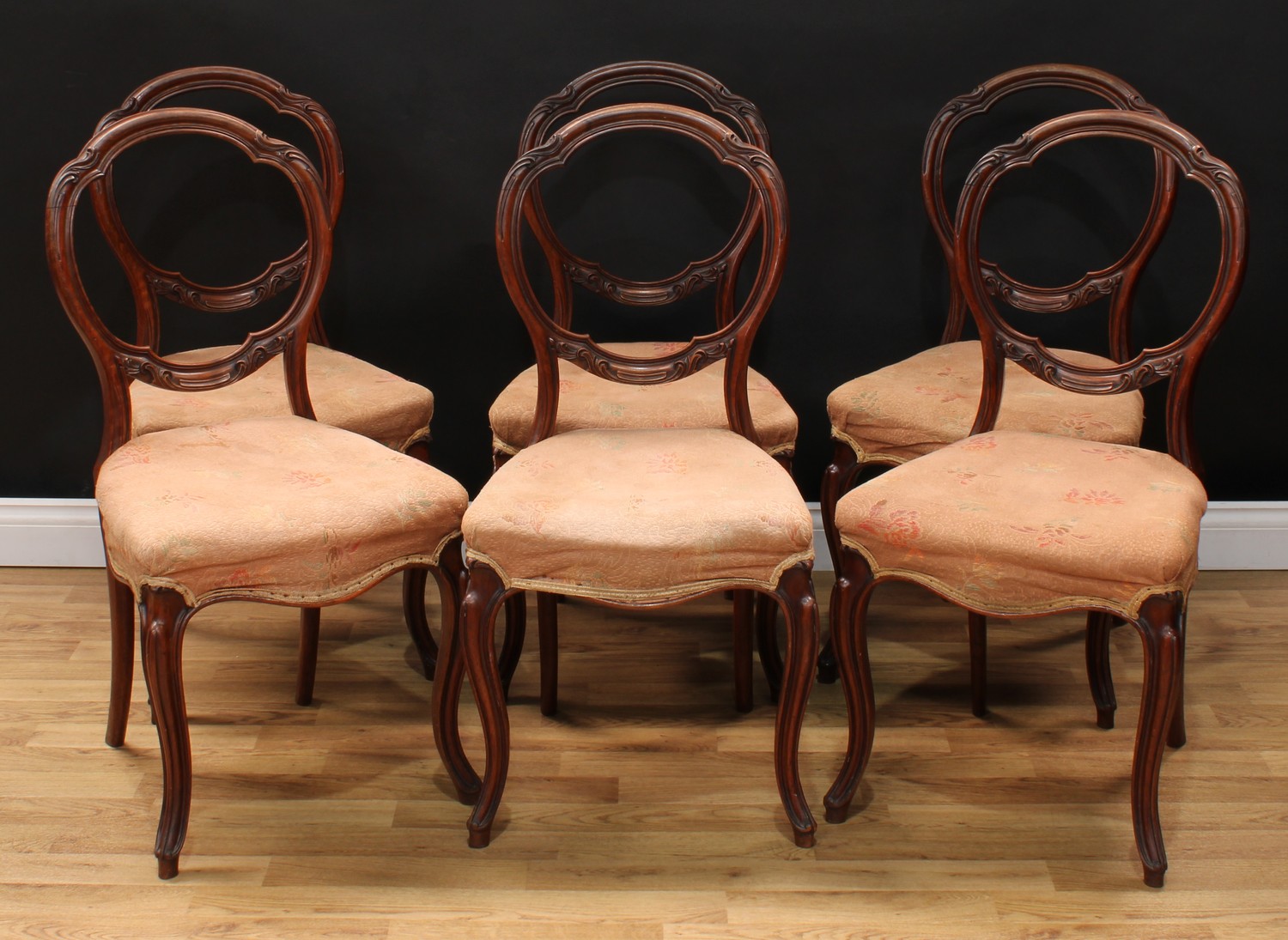 A set of six Victorian mahogany balloon back dining chairs, each with a shaped moulded back carved