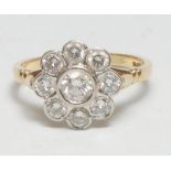 A diamond daisy head cluster ring, central collar set round brilliant cut diamond surrounded by