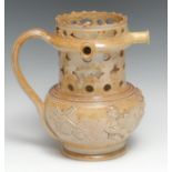 A 19th century brown salt glazed stoneware puzzle jug, pierced with stylised flowerhead and