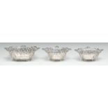 An Edwardian garniture of three shaped rectangular sweetmeat dishes, pierced leafy scroll borders,