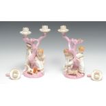 A pair of Royal Worcester figural candelabra, each with two children and a dog