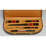 An Art Deco desk suite, comprising pen, seal, paper knife and other accoutrements, cased, 26cm