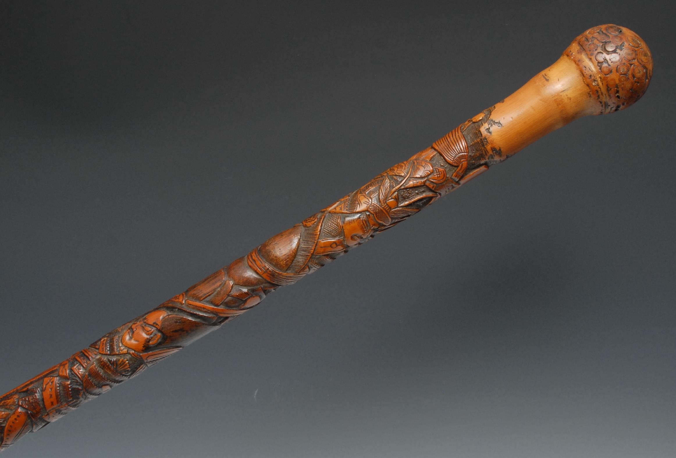 A Japanese bamboo walking stick, well carved with samurai in battle, 87cm long, Meiji period
