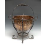 A 20th century copper fuel bin, cast iron wirework stand, 37cm high