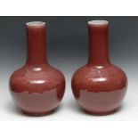 A tall pair of Chinese Sang de Boeuf porcelain globular vases, glazed in merging tones, Blanc de