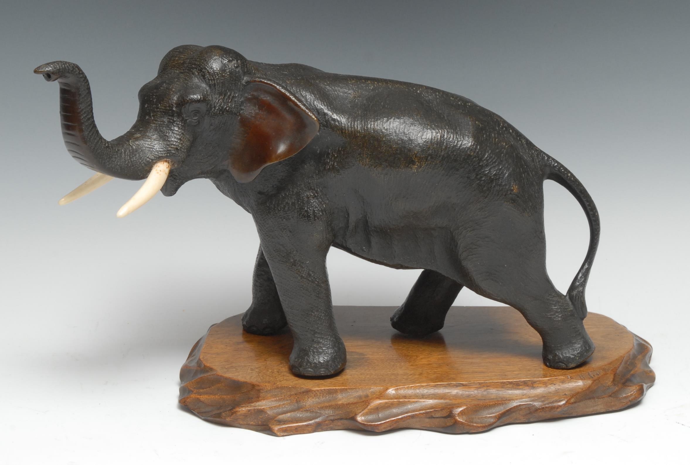 Japanese School (Meiji Period), a dark patinated bronze, of an elephant, trunk raised, 17cm high,