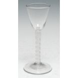 A George III cotton twist wineglass, funnel-shaped bowl, domed circular base, 15cm high, c. 1765